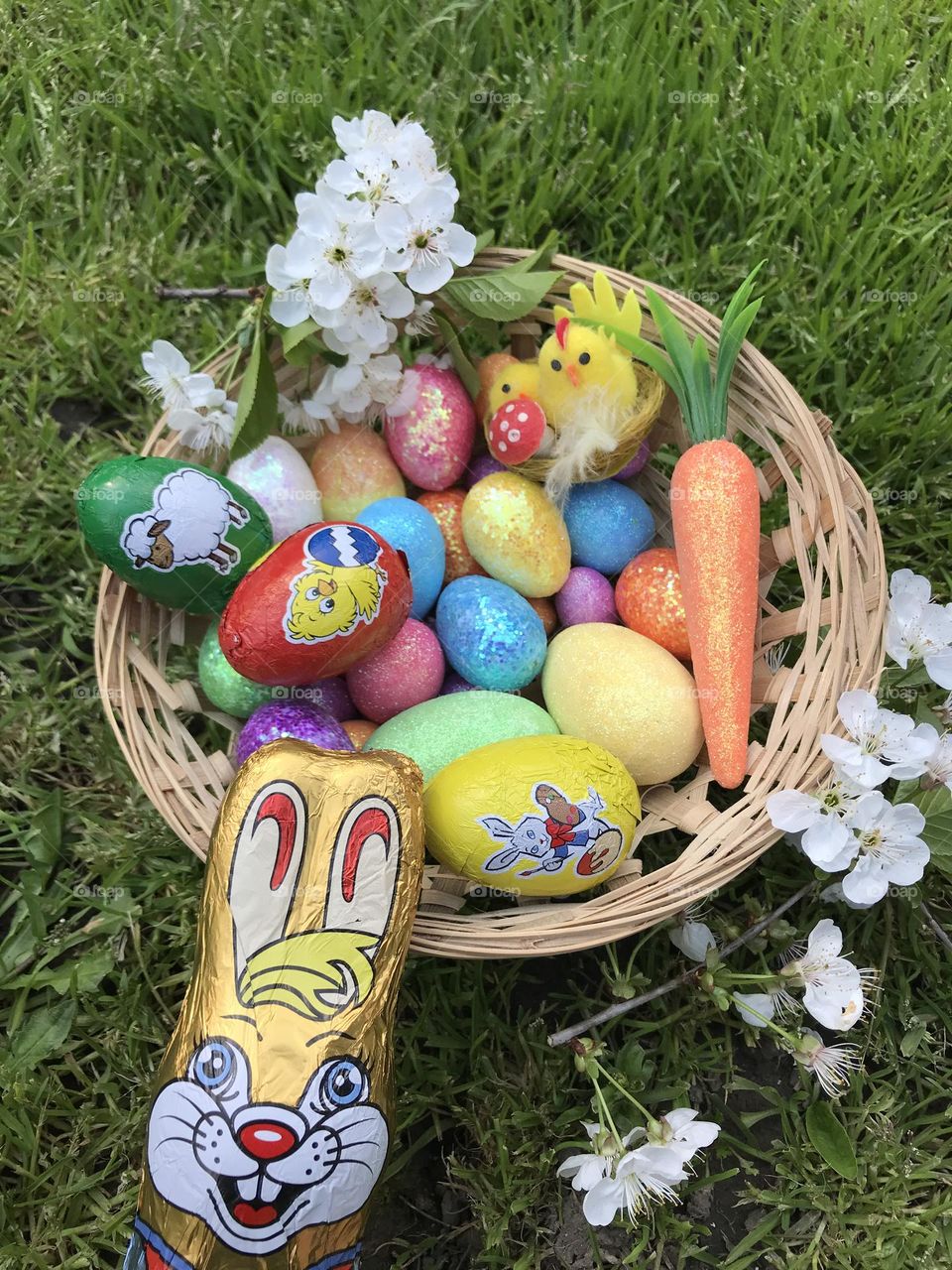 Basket of colorful easter eggs, sweet chocolate eggs, and the chocolate easter bunny