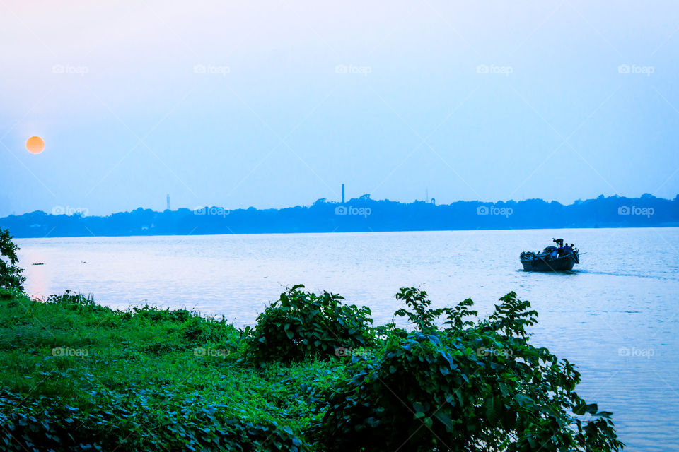 Beautiful panorama of Kolkata city on the river Hooghly in a sunny day. Fishing trallers are floating on the river.