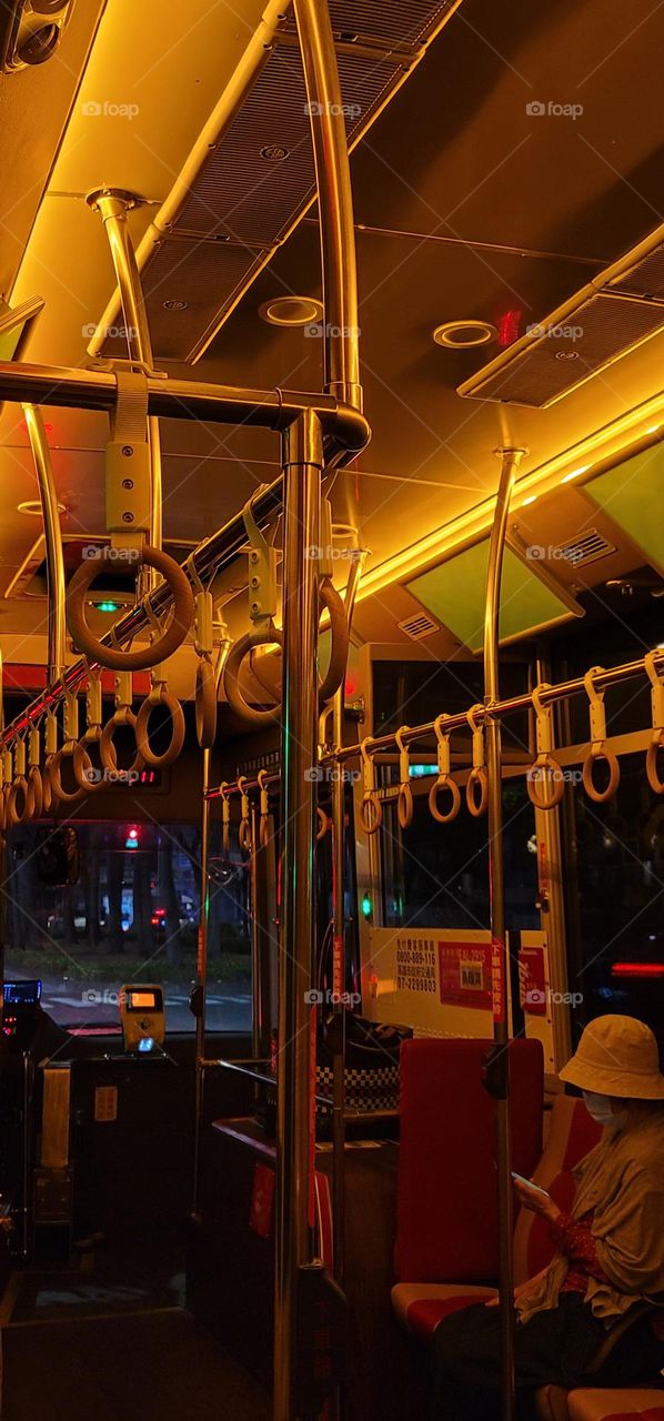 A retro-style bus with a warm yellow light interior.bus seat.card reader.handrail ring.bus interior.Chinese word.