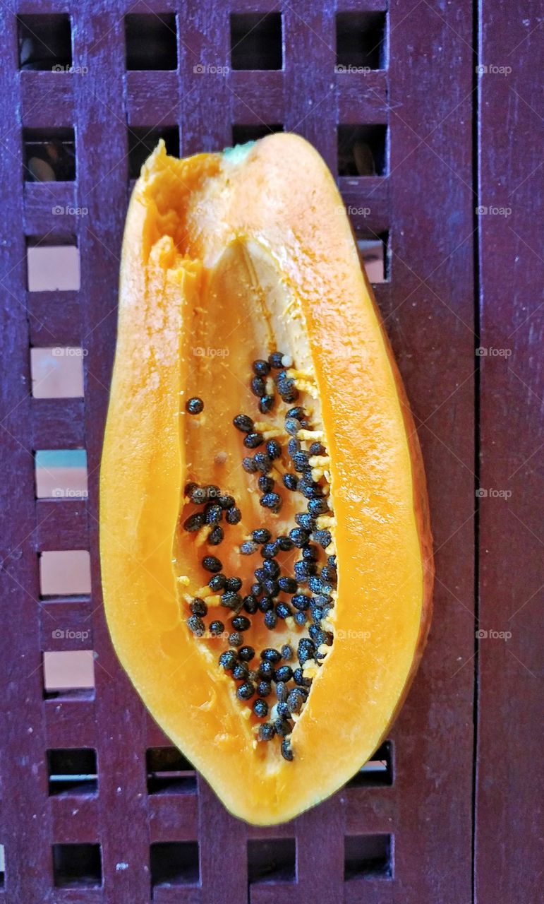 Papaya on purple desk.