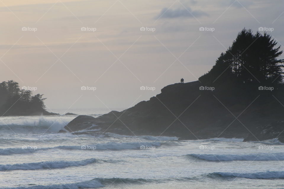 West coast rock ‘face’. This bit of shoreline looks like a profile of a person lying in the ocean with the waves lapping at his chin. A couple of people are resting on his nose and admiring the view.