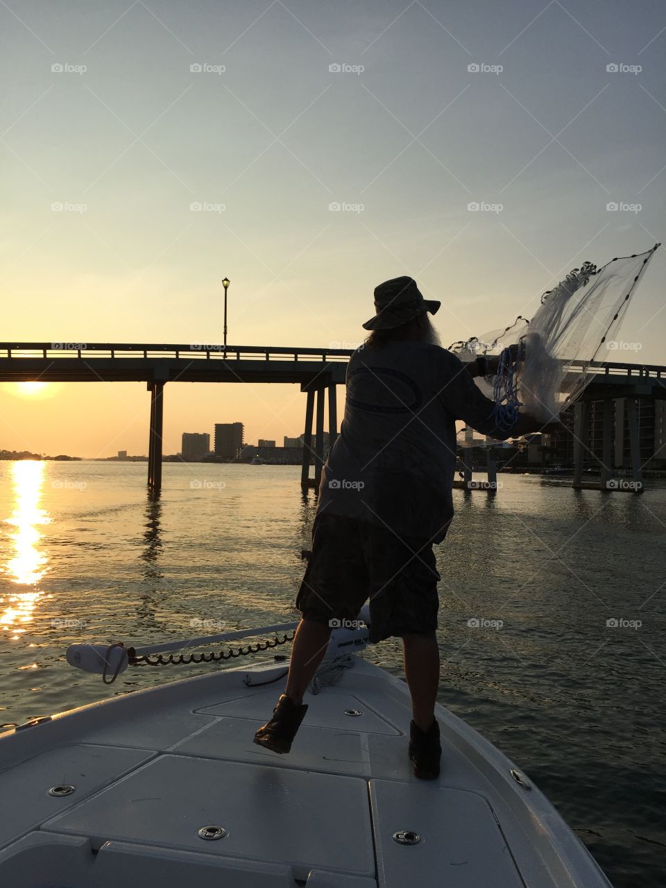 A Fisherman and his Passion. Our charter guide casts a net at sunrise in Orange Beach Alabama.
