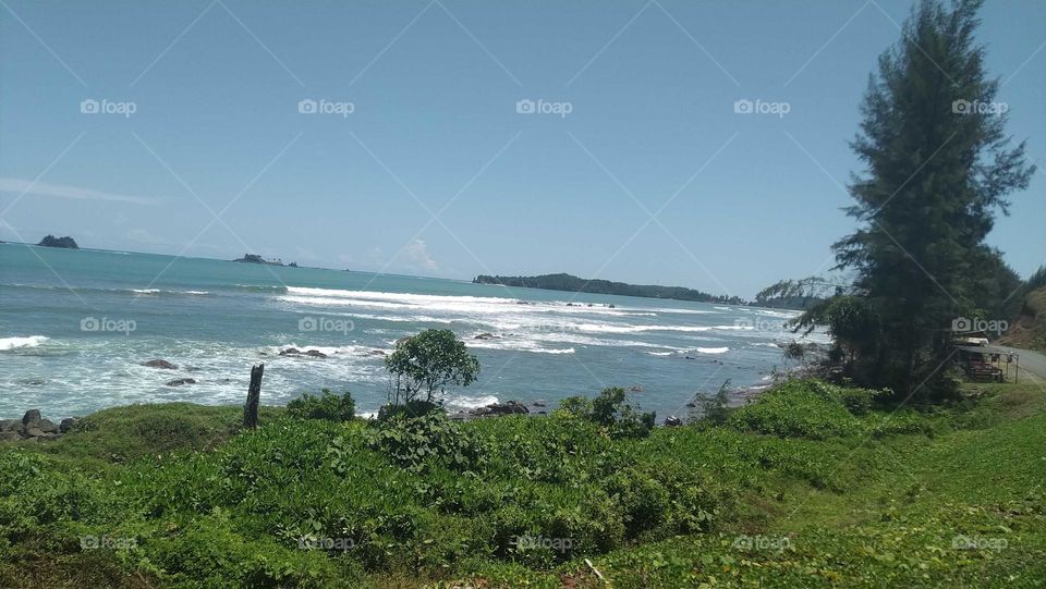 View of beautiful waves crashing onto the beach on a sunny day