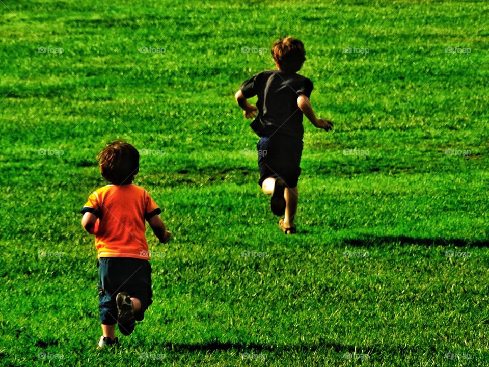 Joyfull boys running through a field