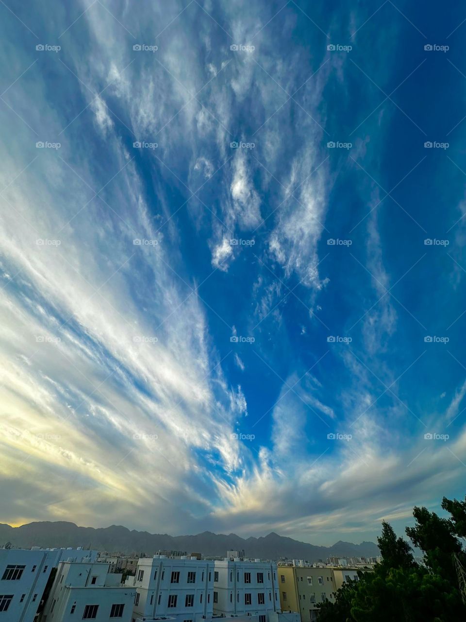 Sunrise with a cloud laden sky and mountains in the background.