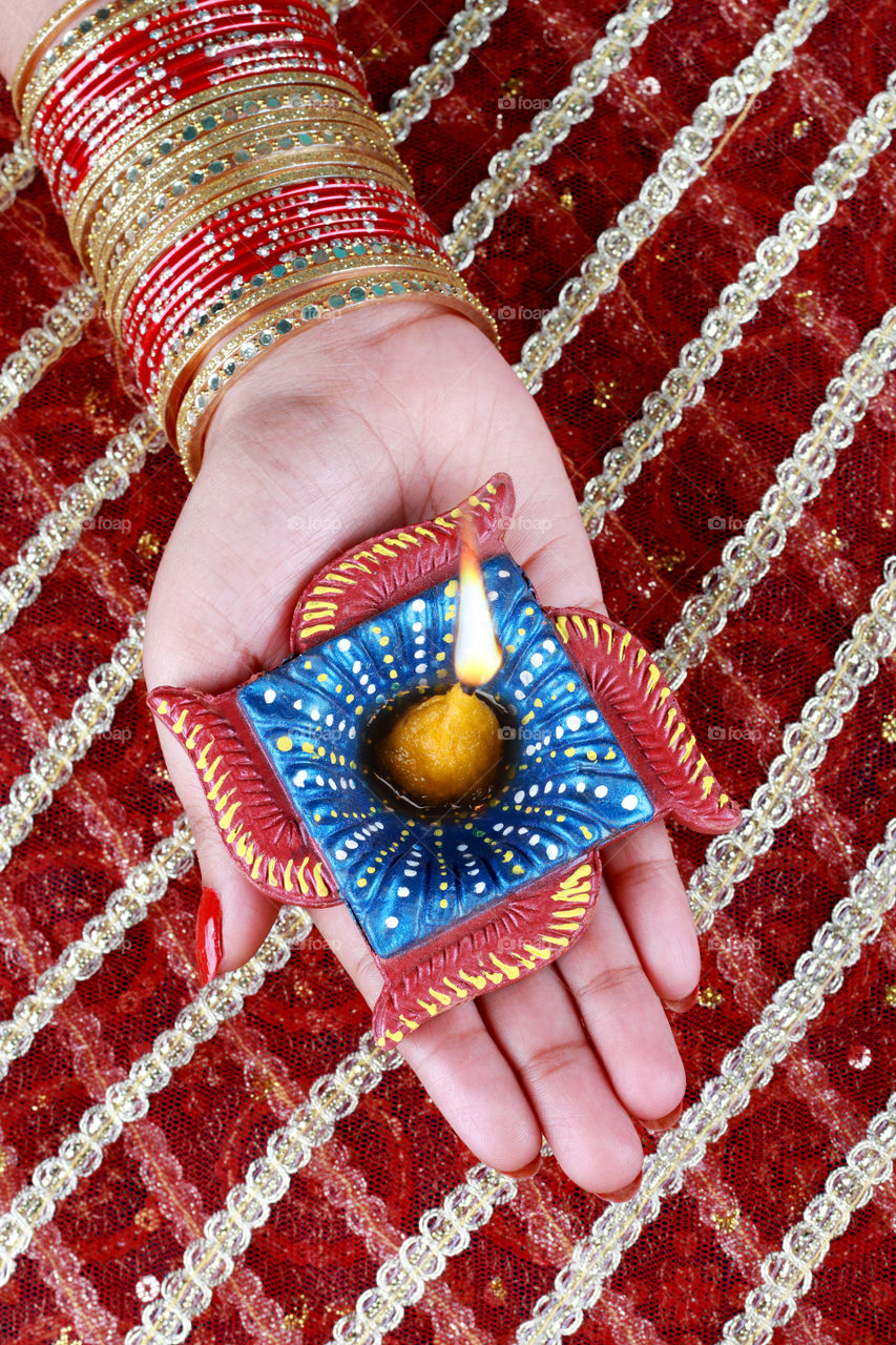 Beautiful Diwali diya oil lamp in a female hand