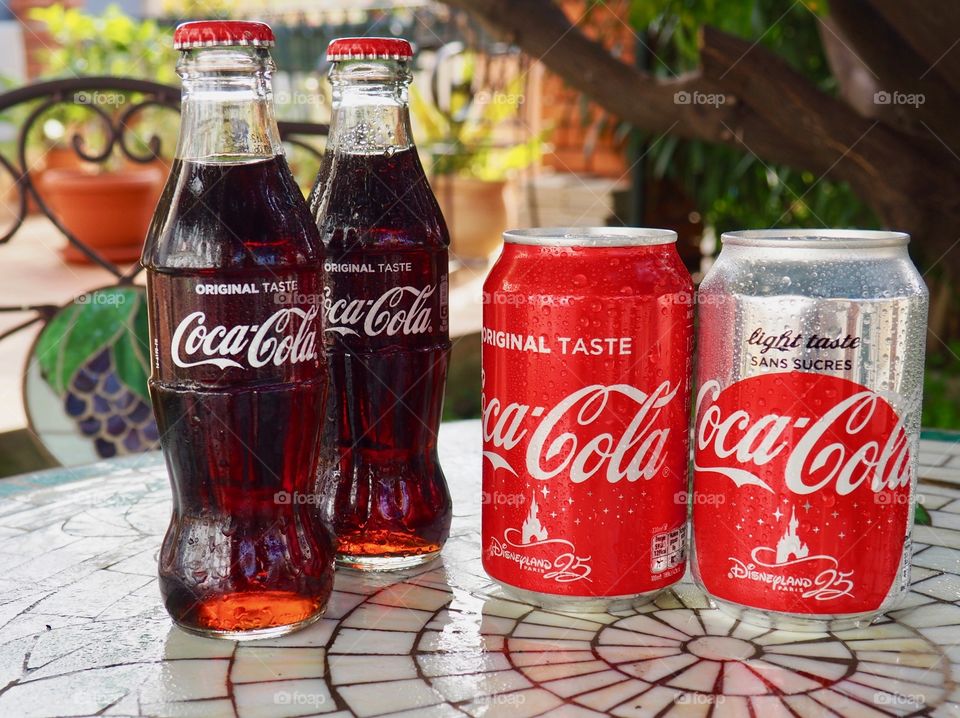 Coca Cola bottles on garden table.