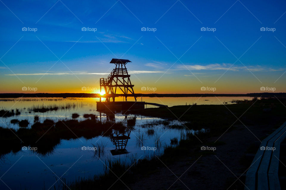 Sunset at the lake with bird watching tower.