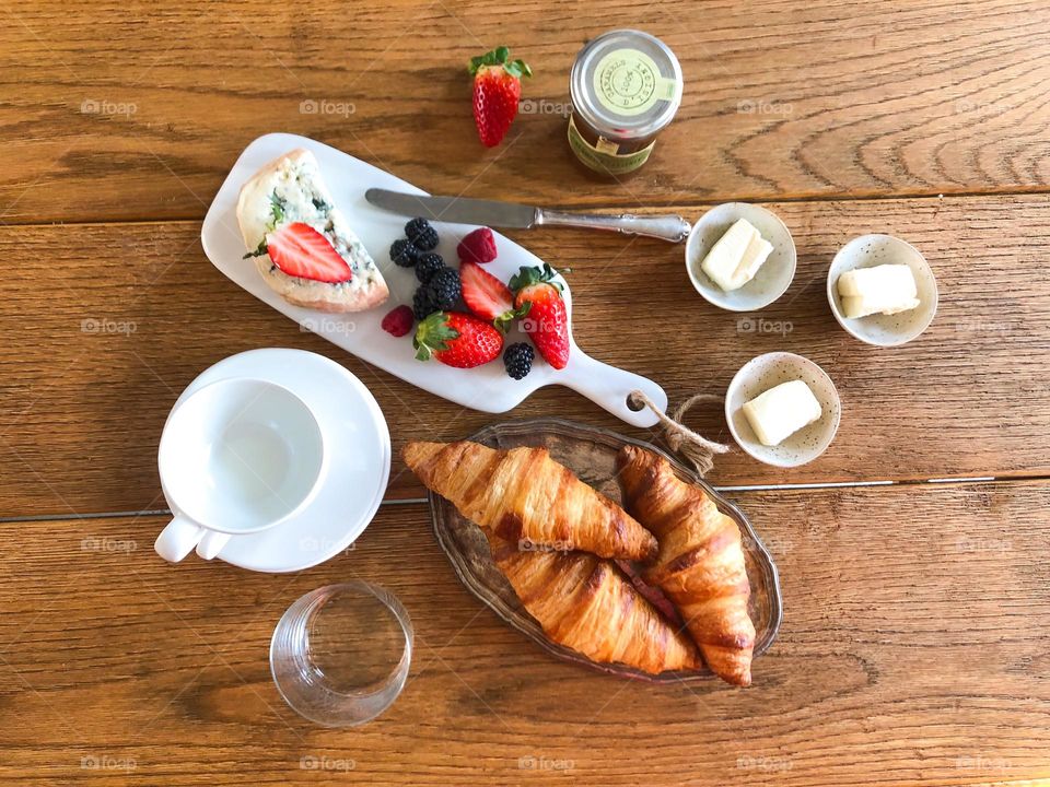 Breakfast with croissants, butter, strawberries, cheese, jam 