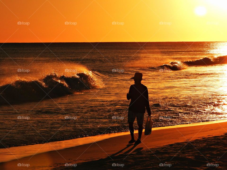 A man Walking Out To Enjoy Perfect Beach Sunset on the Gulf of Mexico