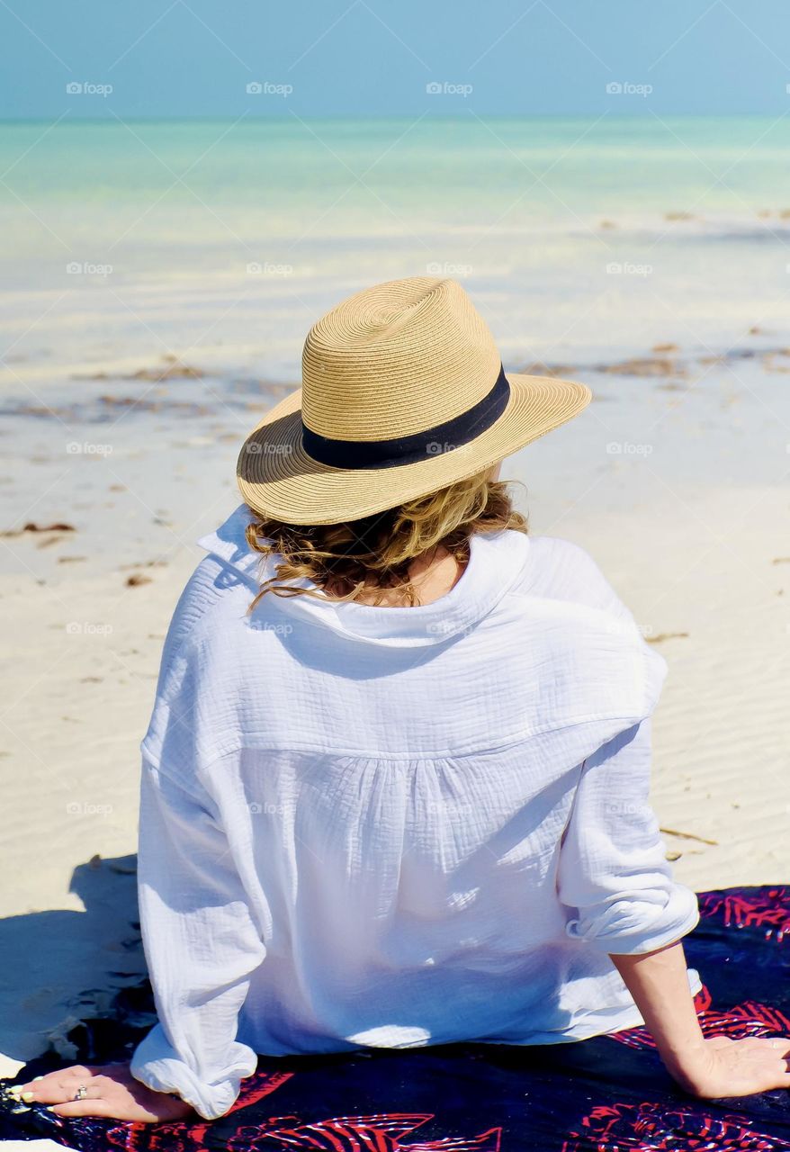 A beautiful woman sits on Punta Mosquito beach on Holbox Island.