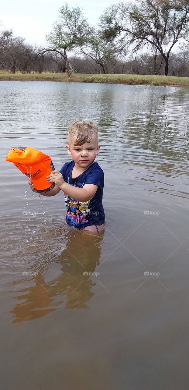 Little boy Swimming in waterhole on farm