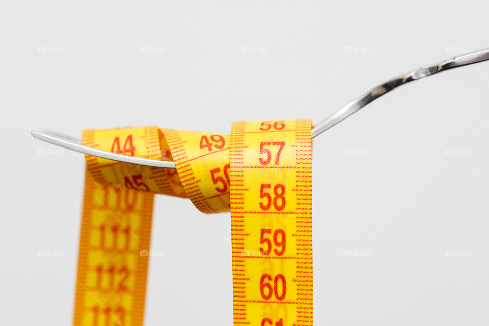 Diet for weight loss , measuring tape with fork for take care healthy eating concept