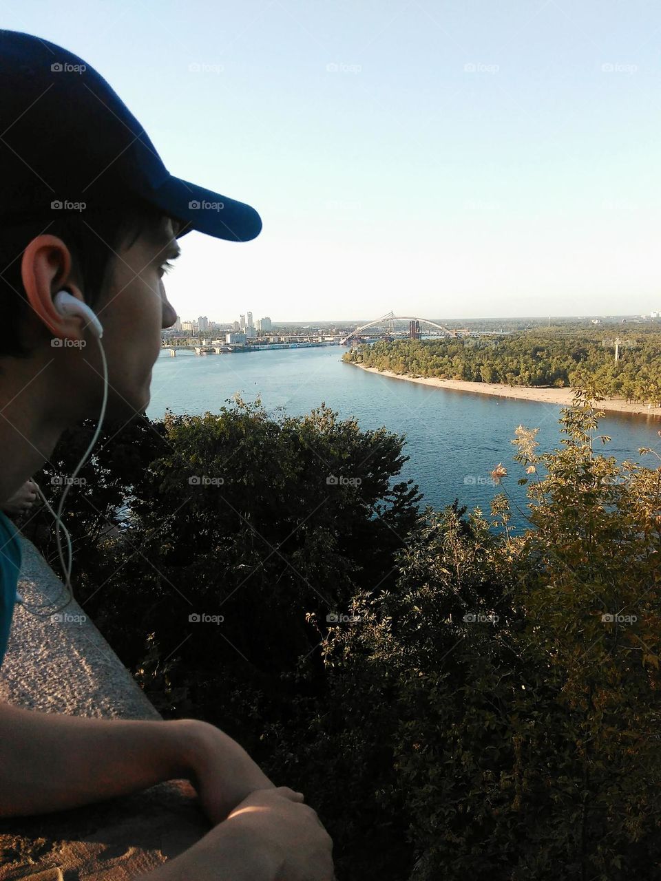 the guy listens to music in headphones and looks at the beautiful landscape