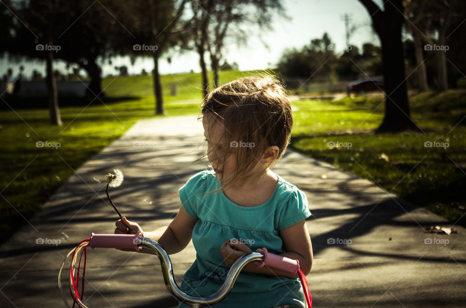 dandelion . My daughter at the park on her bike one day