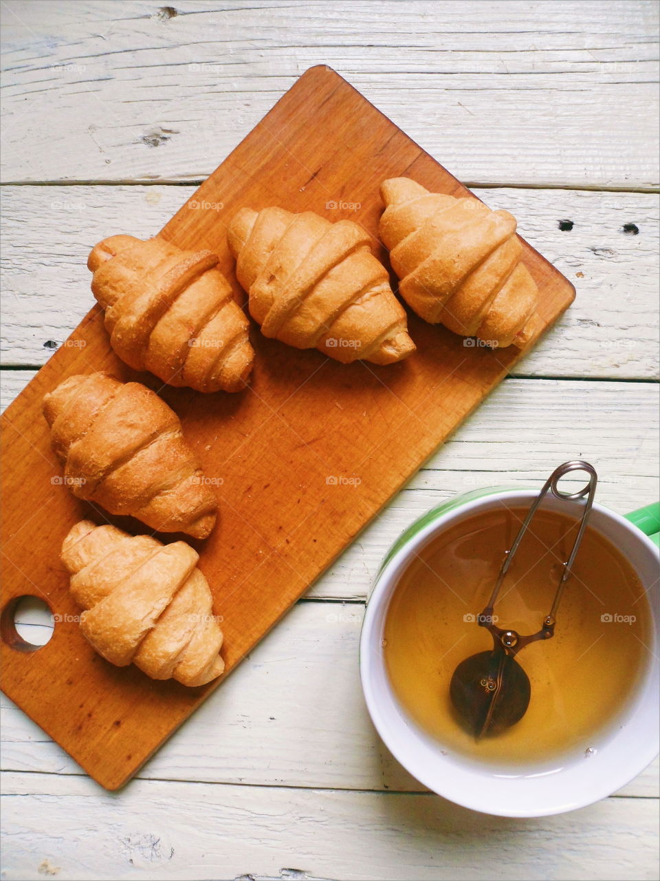 croissants and green tea on white boards