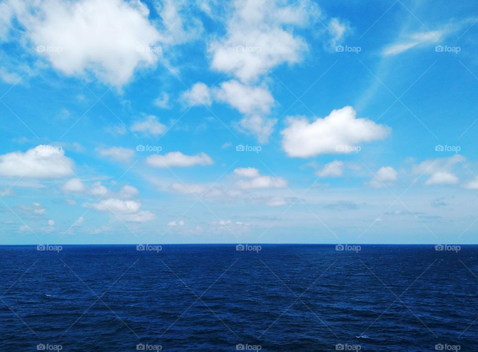 Cloudscape on the sea, "a bird" cirrostratus among cumulus clouds.