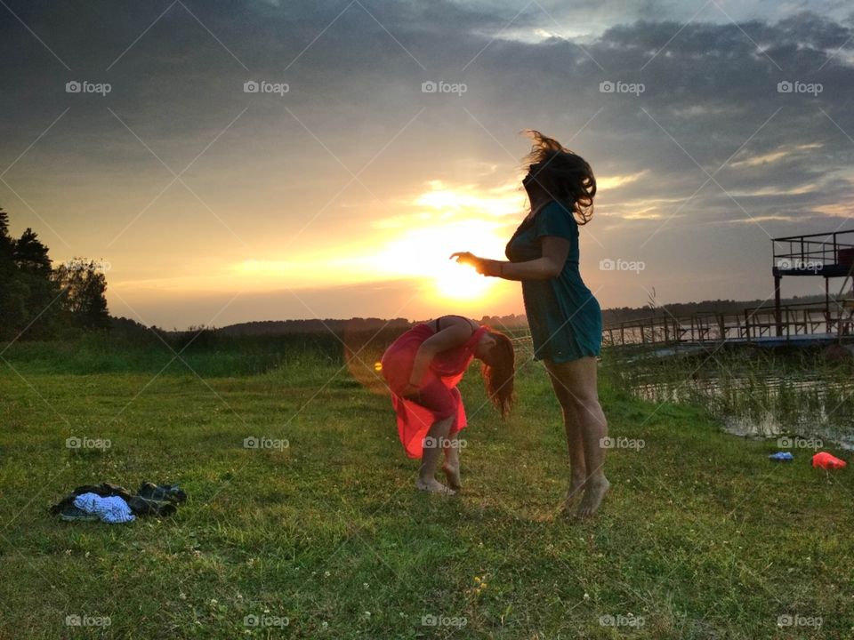 Танцы  двух девушек на закате солнца, на озере .
