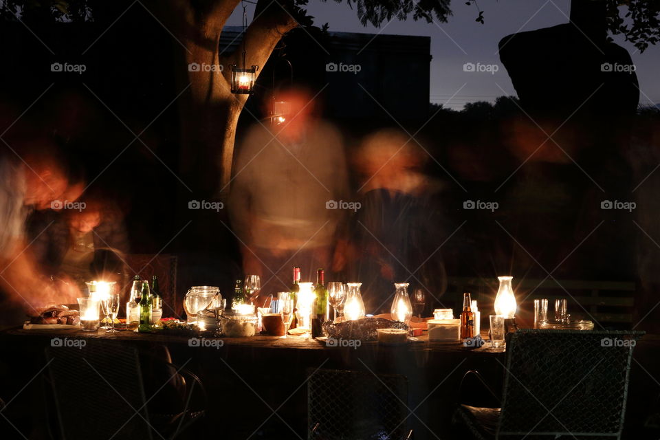 Long-exposure photograph of our evening supper by candlelight, making the people look like ghosts