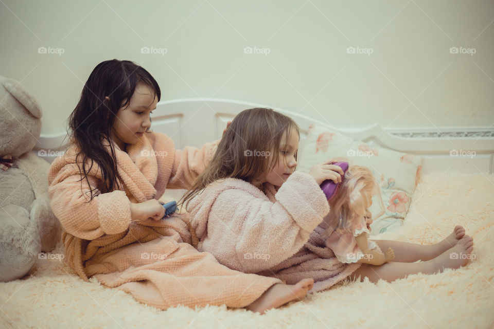 Little sisters in bath robes with combs