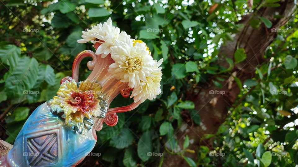 Beautiful white flowers in a colourful flowerpot with a flower sculpture, Flowers in a vase, colourful vase, white flowers in a vase