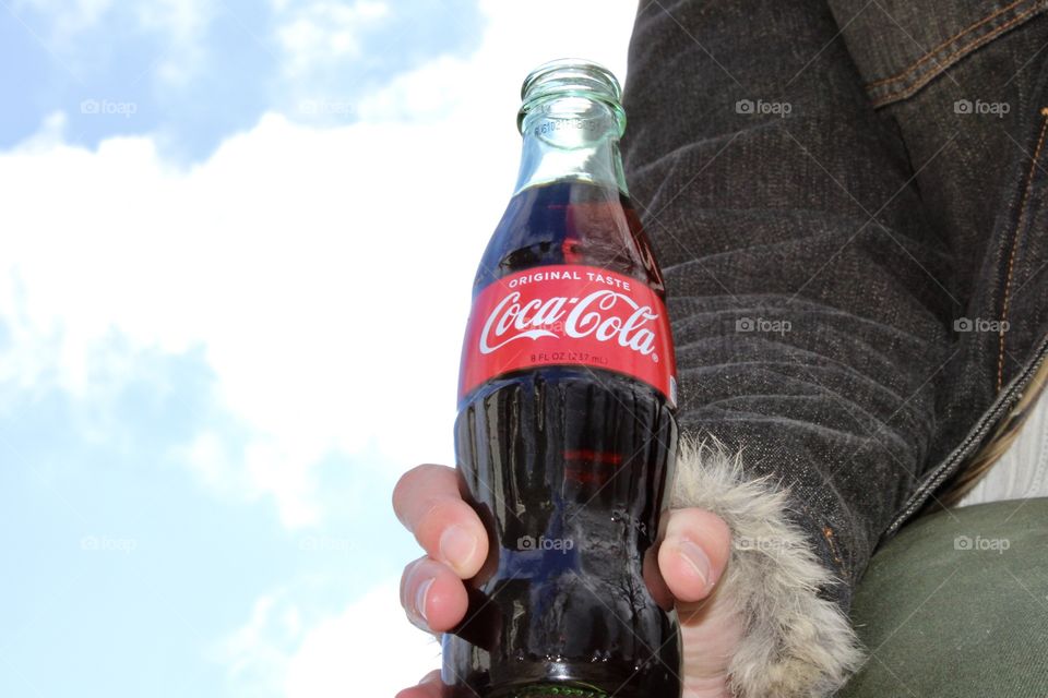Holding a Coca Cola with Sky Background 