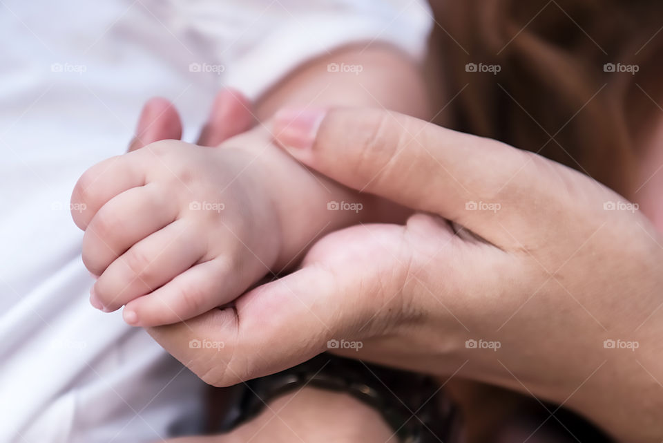A person holding infant hand