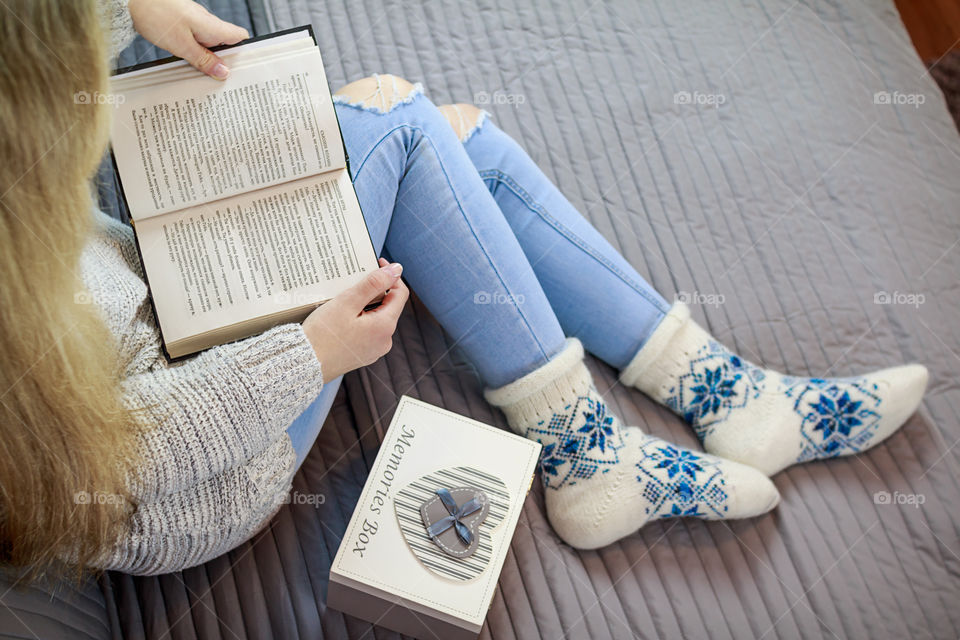 girl sitting on the bed and reading a book