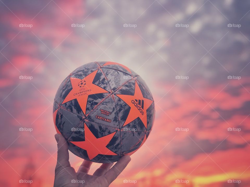 Crazy sunset with soccer ball in hand