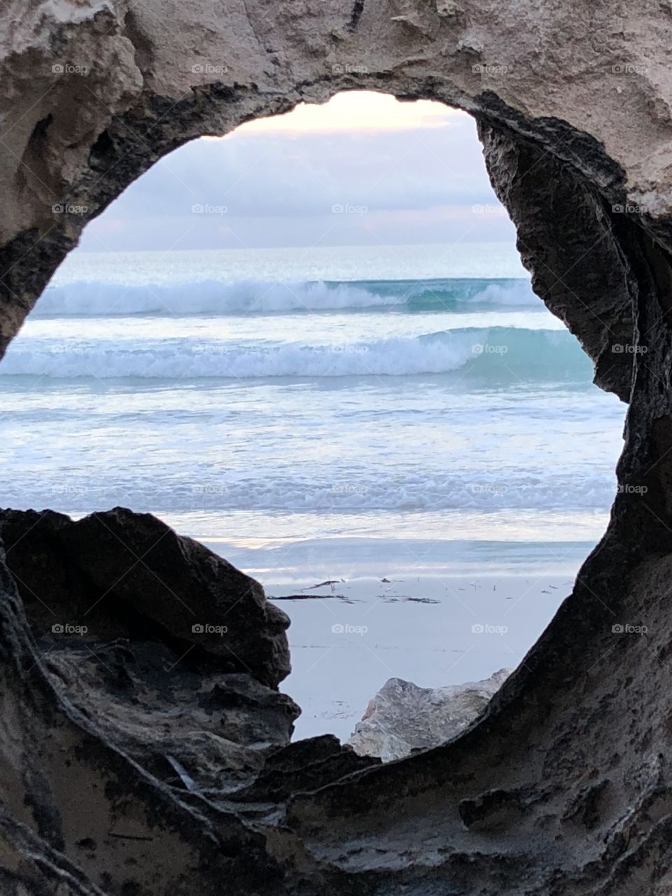 The surf through a rock. Can you see the face in the rock? Amazing, framed in rock