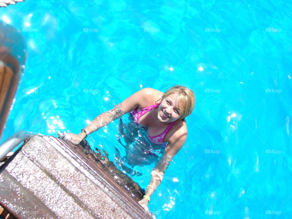 Woman in swimming pool looking up