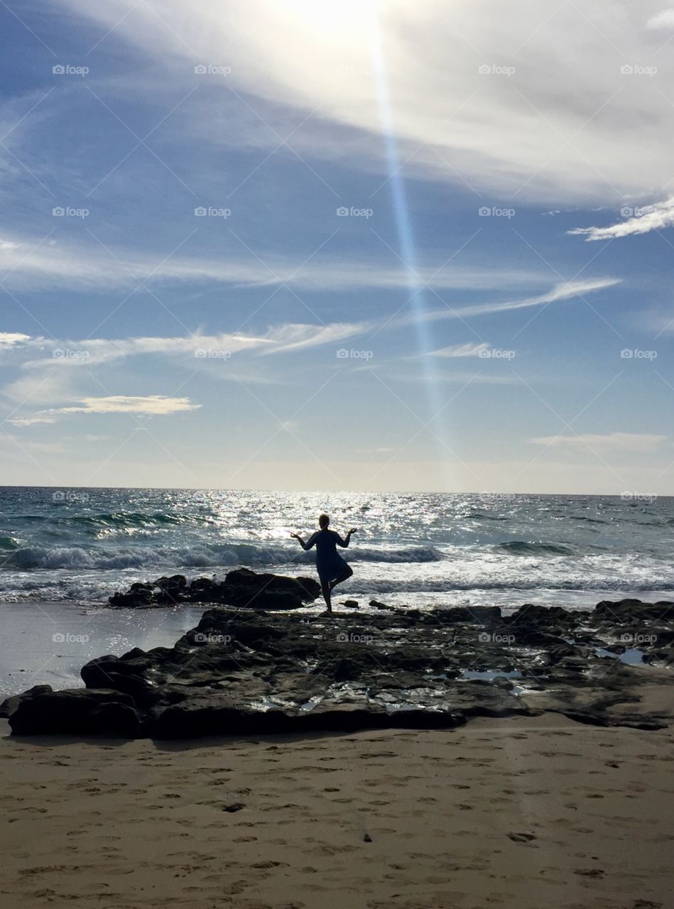 Lady doing yoga on a beach harmony and relaxation