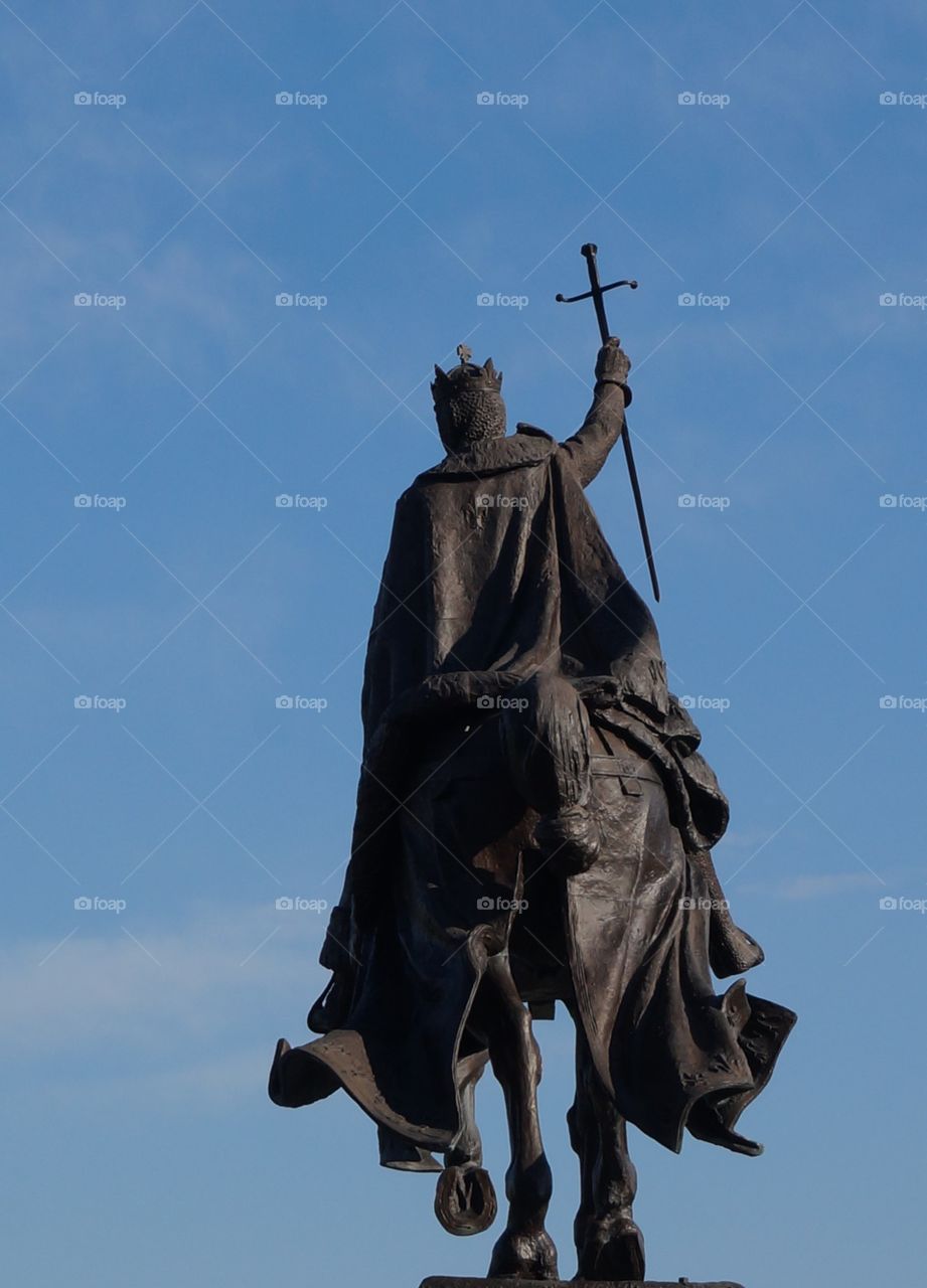 Statue with cross held high.  St Louis museum.