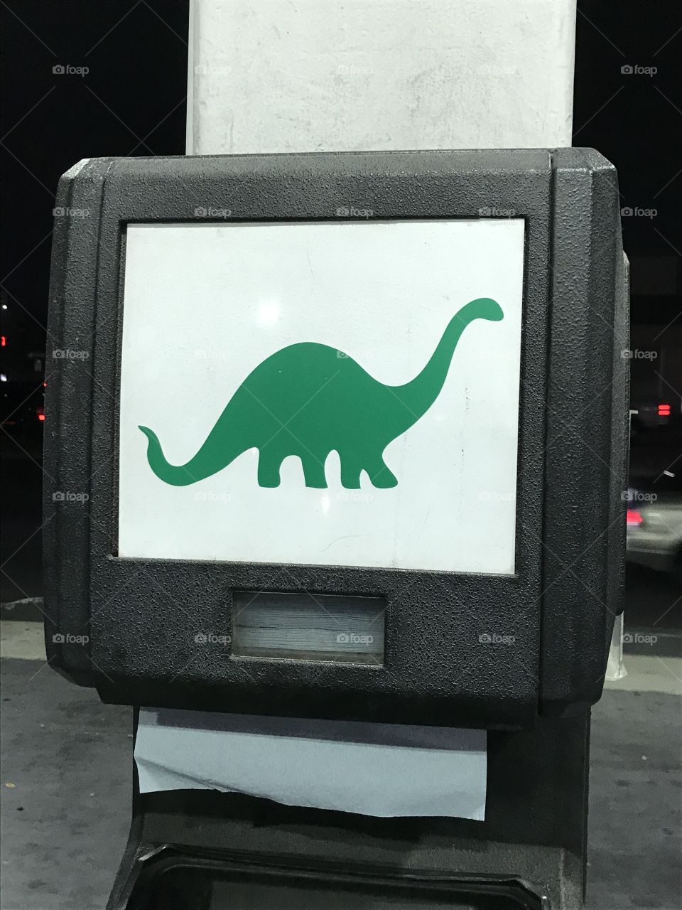 A paper towel dispenser at the gas station. It bears an impressive logo of the company.