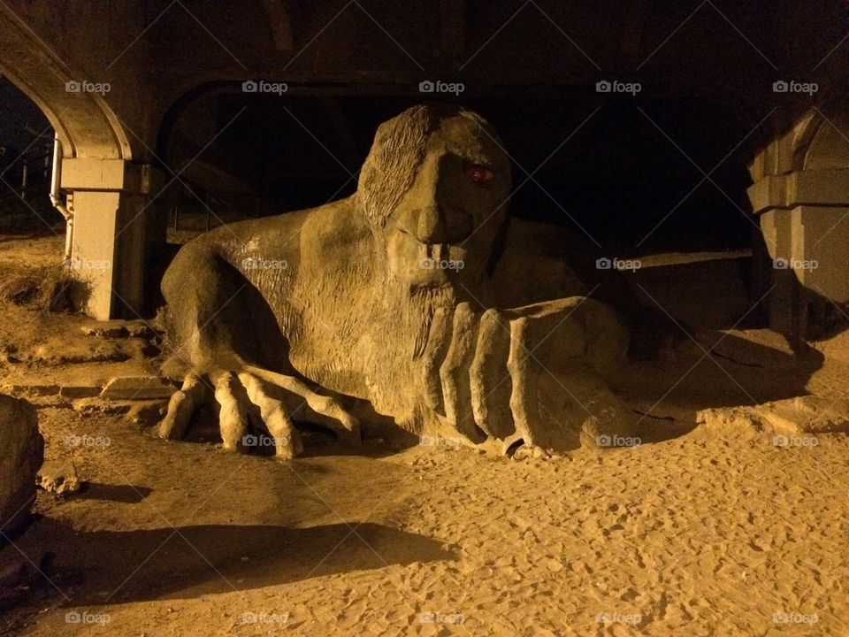A troll under a bridge. This is the famous troll made out of sand and dirt under a bridge in Fremont, Seattle known by the locals as "Fremont Troll".
