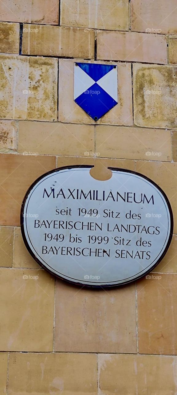 This plaque tells what the “Maximilianeum” in “Munich” is all about: It has been the seat of the “Bavarian State Parliament” since 1949 and from 1949 to 1999 also of the “Bavarian Senate”. 2024. Hypnotic Productions