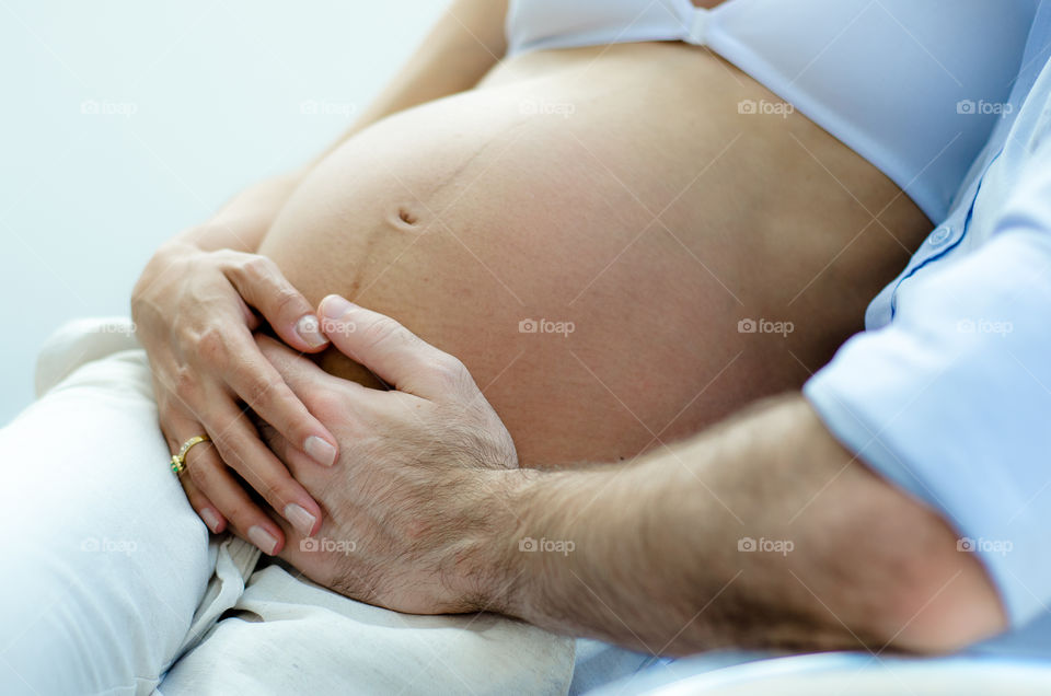 Pai e mãe segurando barriga