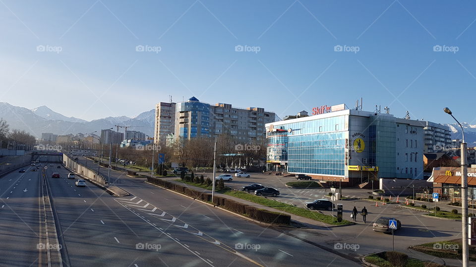 city view with mountains, buildings and people