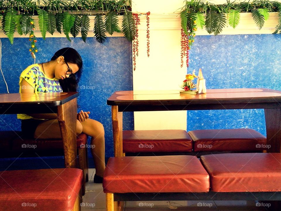 young lady using cellphone inside a cafe