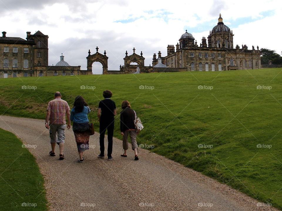 A family enjoys a nice stroll together while visiting the grounds of Castle Howard in the English countryside. 