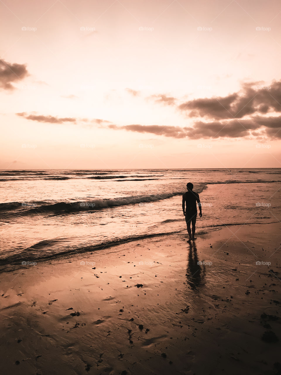 Bali Indonesia, Nov 2019: silhouette of a man walking on the beach during sunset time