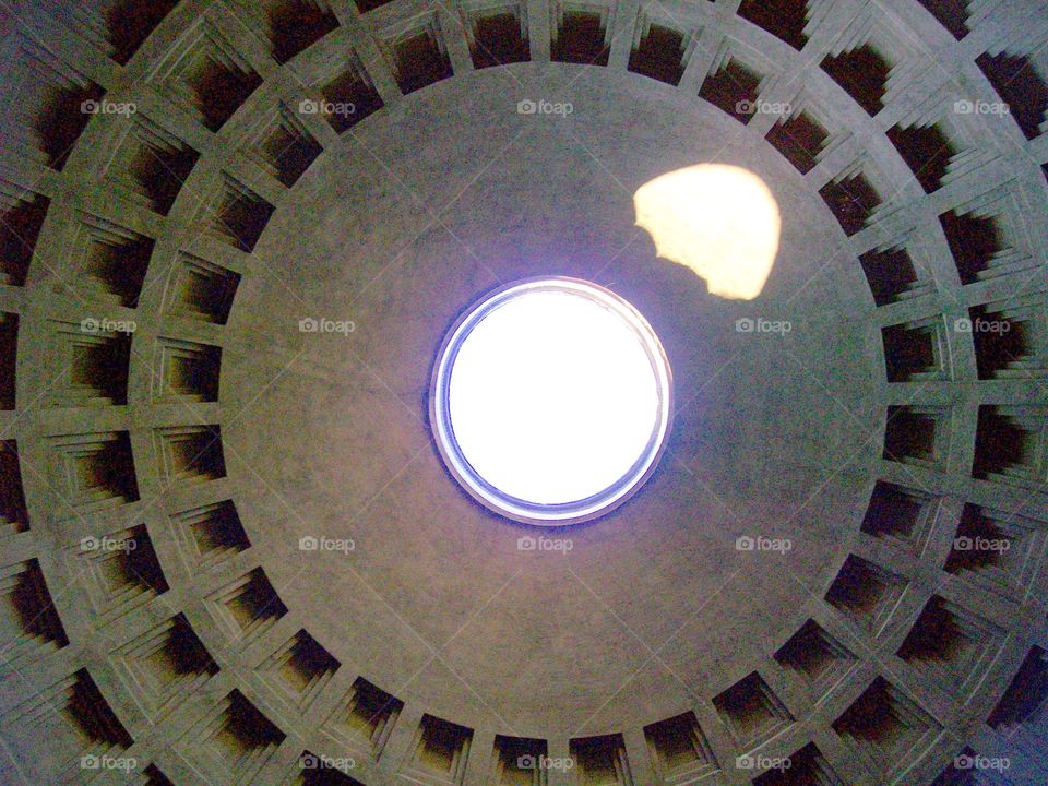 The great architecture of this ancient Roman landmark- the Pantheon with light forming unique shadows as it shines through the singular oculus 