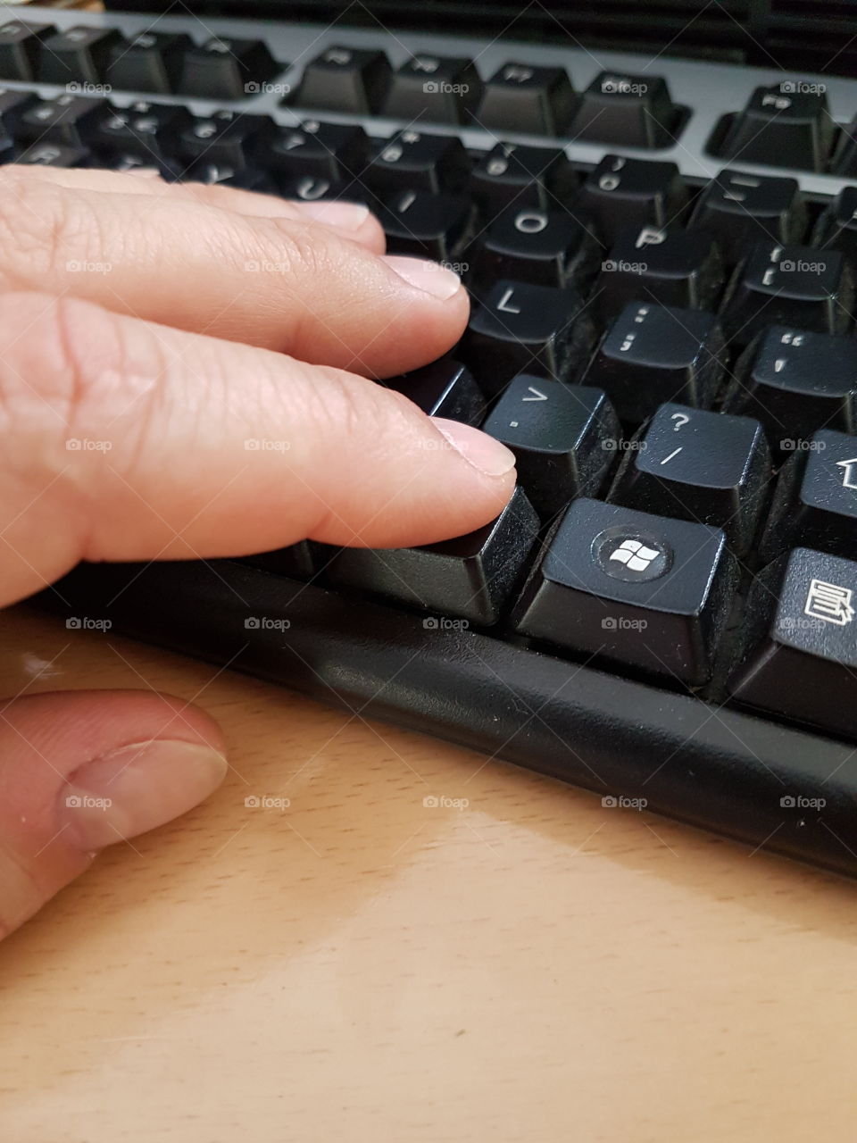 male hand typing on a keyboard, male hand close-up, desktop computer