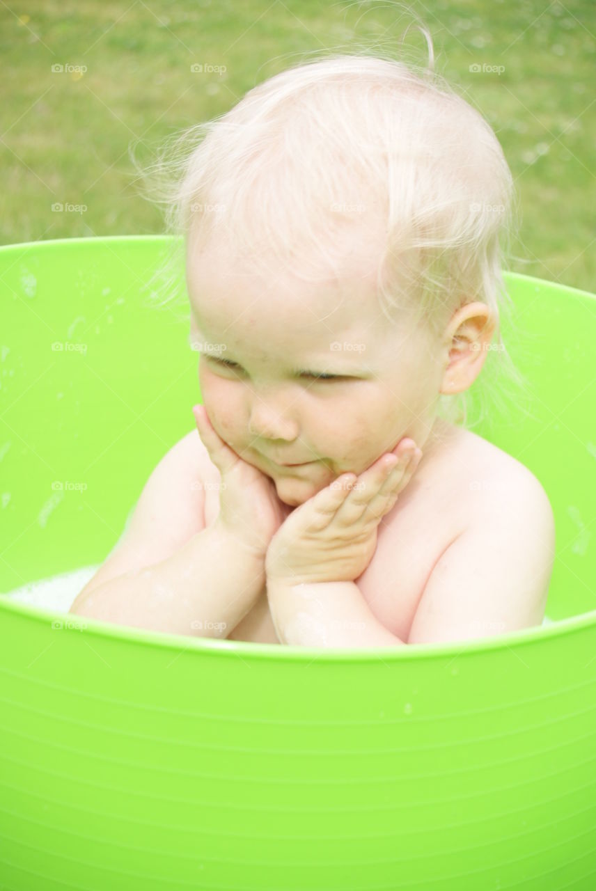 Blonde baby in green tub