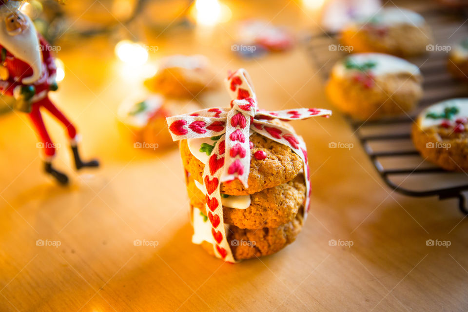 Handmade gifts are so special. Handmade Christmas cookies with hear ribbon with fairy lights I'm the background.