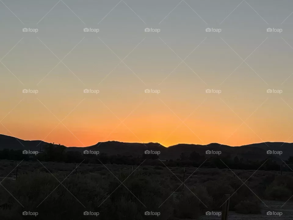 A bright orange sunset with mountains