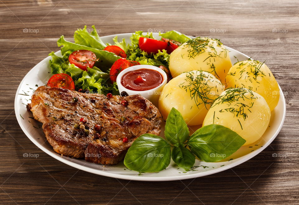Grilled steak with boiled potatoes on plate