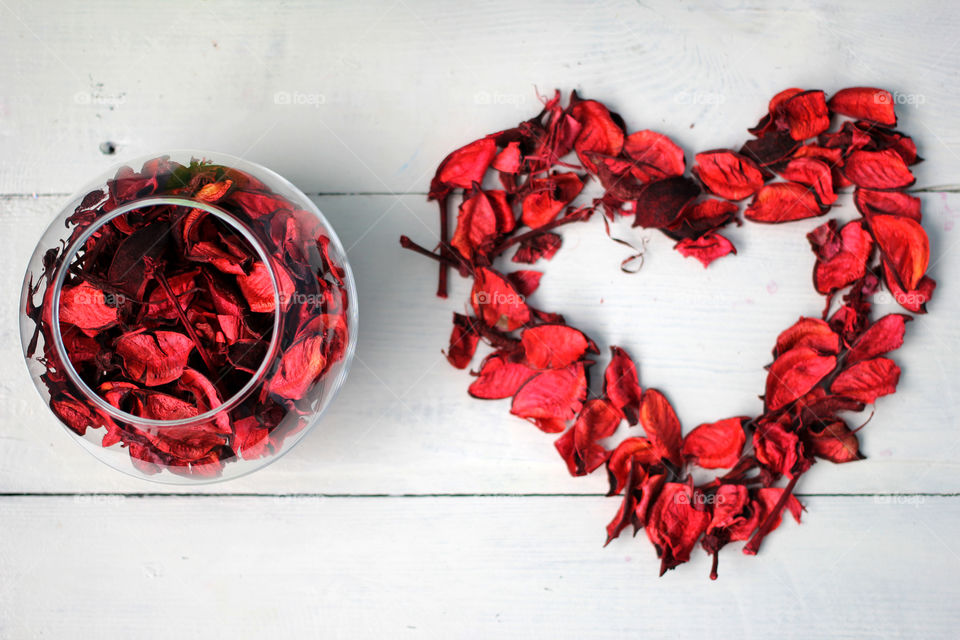 The figure in the form of a heart and a bowl of rose petals on a white background