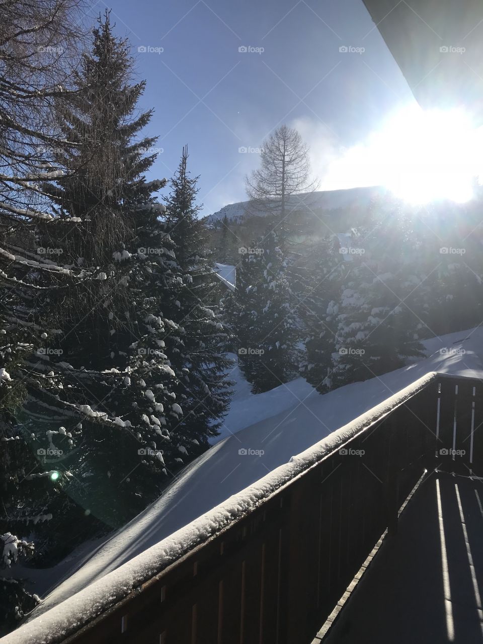 Sun shining in outside of of bungalow in the Austrian Alps. Beautiful fresh powdery snow