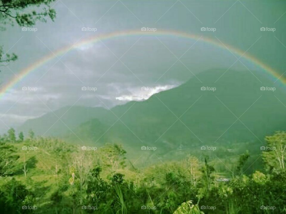 beautiful scenery in the mountains when a rainbow crosses the mountain